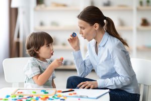 Female speech therapist curing child's problems and impediments.