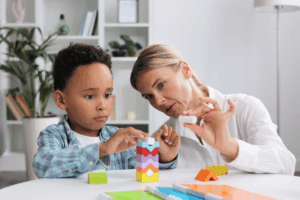 Therapist demonstrating stimulus control transfer in ABA therapy with child