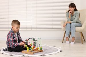 Behavior interventionist working with child during ABA therapy session