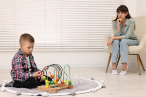 Behavior interventionist working with child during ABA therapy session