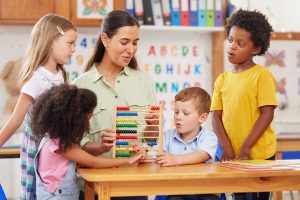 A child engaging in play-based ABA therapy with a therapist using naturalistic teaching strategies